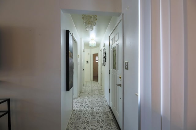 hallway with an inviting chandelier