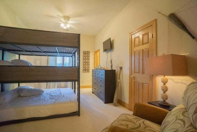 carpeted bedroom with ceiling fan and a textured ceiling