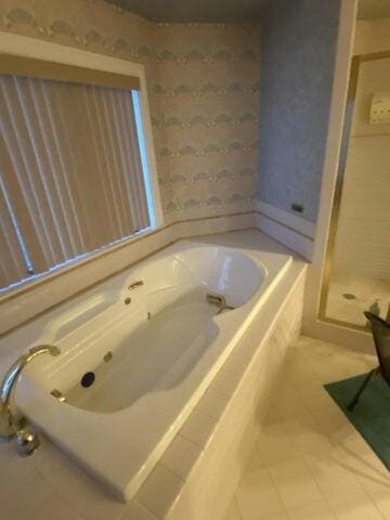 bathroom with shower with separate bathtub and tile patterned floors