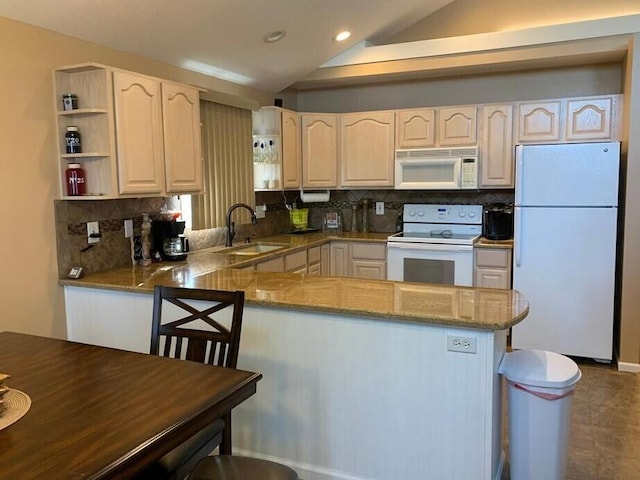 kitchen featuring sink, white appliances, kitchen peninsula, and vaulted ceiling