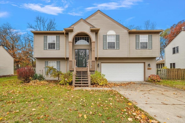 raised ranch featuring a garage and a front yard