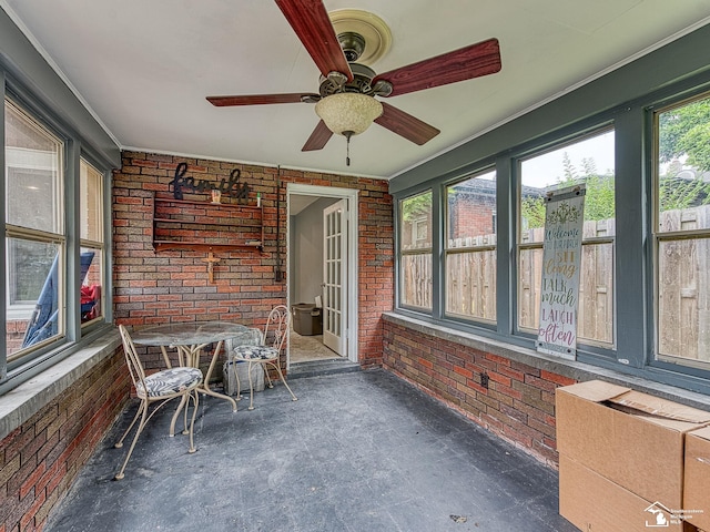 unfurnished sunroom featuring ceiling fan