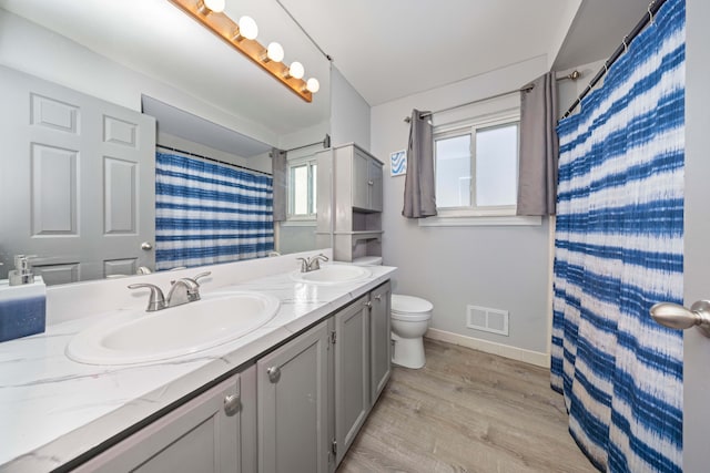 bathroom featuring toilet, a shower with curtain, hardwood / wood-style floors, and vanity