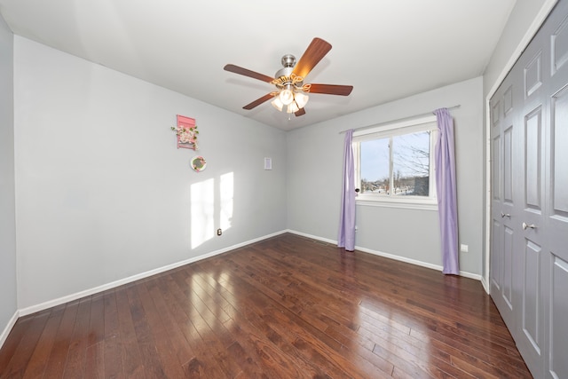 unfurnished bedroom with ceiling fan, a closet, and dark hardwood / wood-style floors