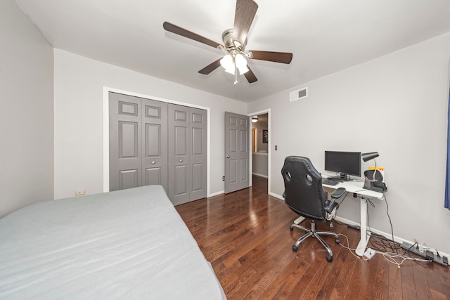 bedroom featuring ceiling fan, dark hardwood / wood-style flooring, and a closet