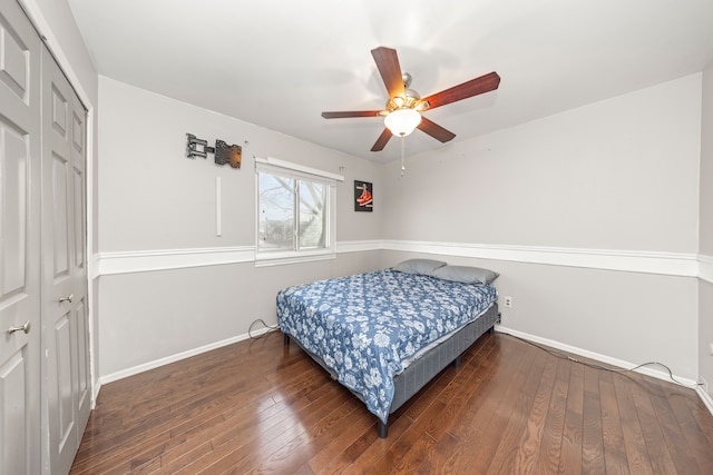 bedroom featuring ceiling fan, dark wood-type flooring, and a closet