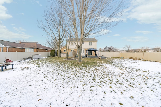 snow covered back of property featuring a gazebo