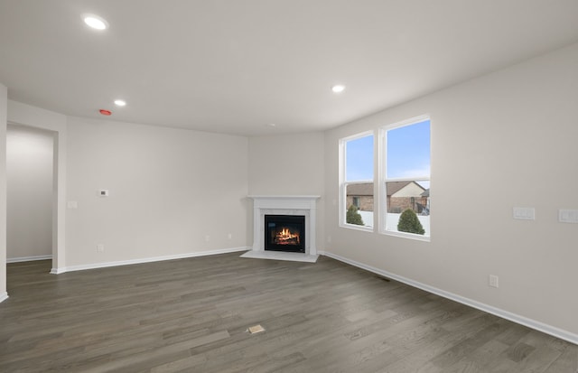 unfurnished living room with dark hardwood / wood-style floors and a high end fireplace