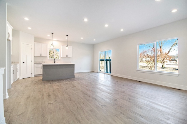 unfurnished living room with light wood-style flooring, visible vents, baseboards, and recessed lighting