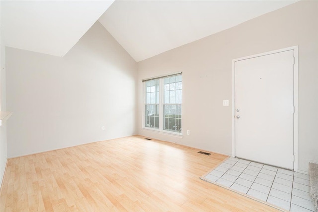 foyer entrance with vaulted ceiling and light hardwood / wood-style floors