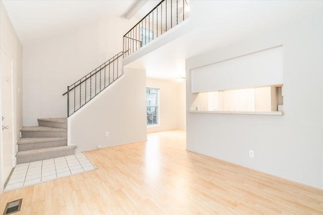 interior space with a high ceiling and light hardwood / wood-style flooring