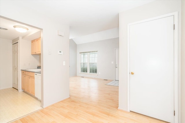 kitchen with vaulted ceiling, white dishwasher, light hardwood / wood-style floors, and light brown cabinets