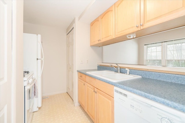 kitchen featuring white appliances, light brown cabinetry, and sink