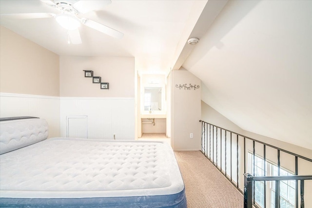 carpeted bedroom with lofted ceiling, ensuite bath, and ceiling fan