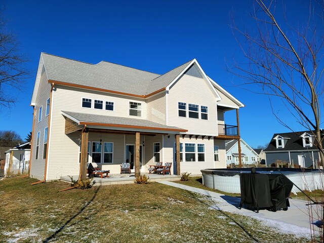 back of house with a covered pool, a yard, and a patio area