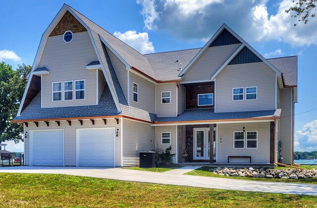 view of front of home with central AC unit, a garage, and a front lawn