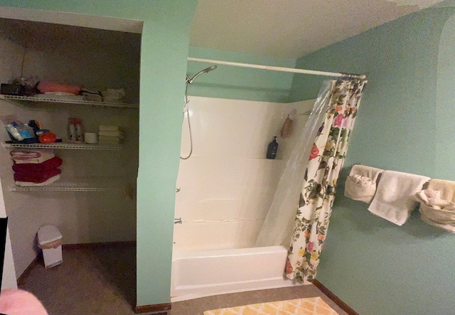 full bathroom with shower / tub combo with curtain and baseboards