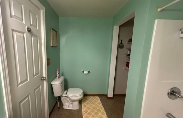 full bath featuring baseboards and toilet