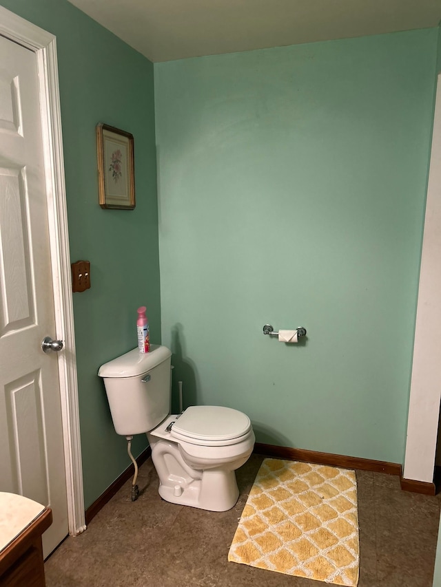 bathroom with baseboards and toilet