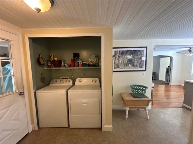 washroom featuring laundry area, baseboards, arched walkways, and washer and dryer