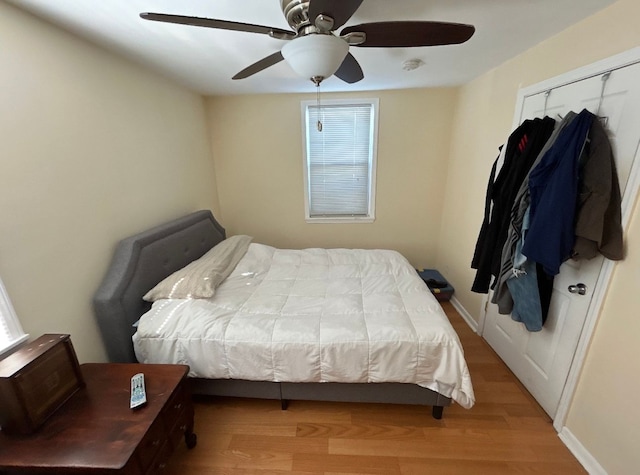 bedroom with a ceiling fan, baseboards, and wood finished floors