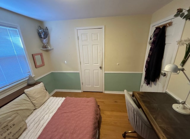 bedroom featuring a closet, light wood-style flooring, and baseboards