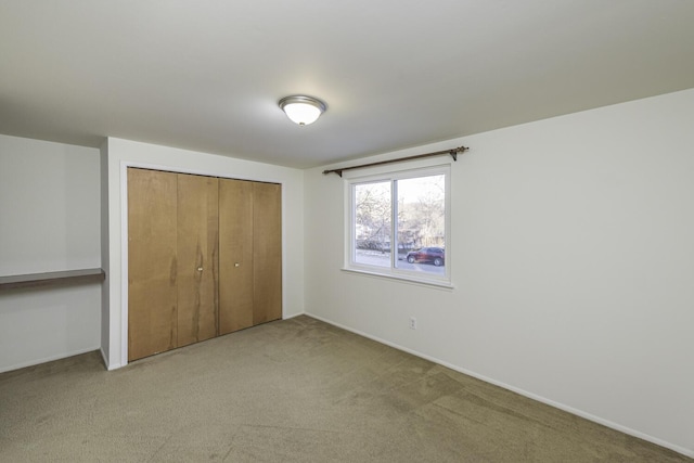 unfurnished bedroom with a closet and light carpet