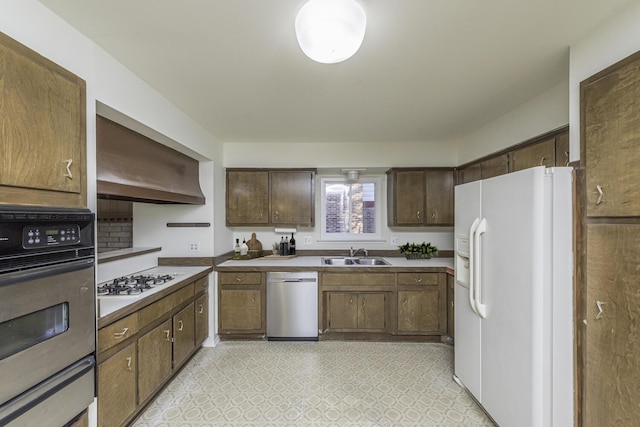 kitchen with appliances with stainless steel finishes, sink, and wall chimney exhaust hood