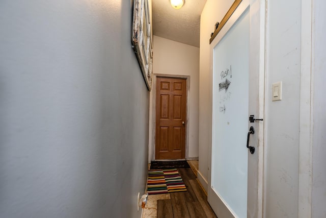 doorway to outside with a barn door, dark hardwood / wood-style floors, and a textured ceiling