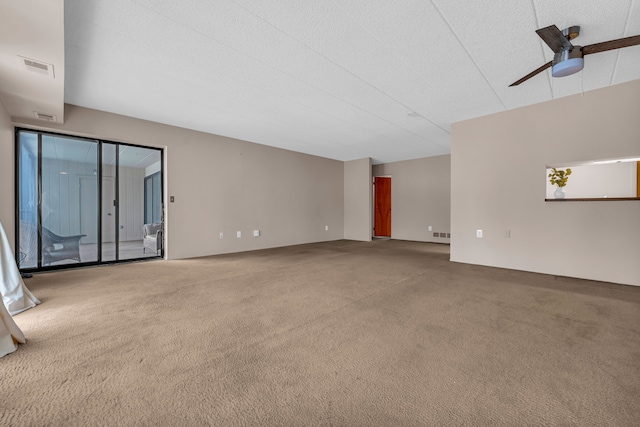 unfurnished living room featuring ceiling fan and carpet