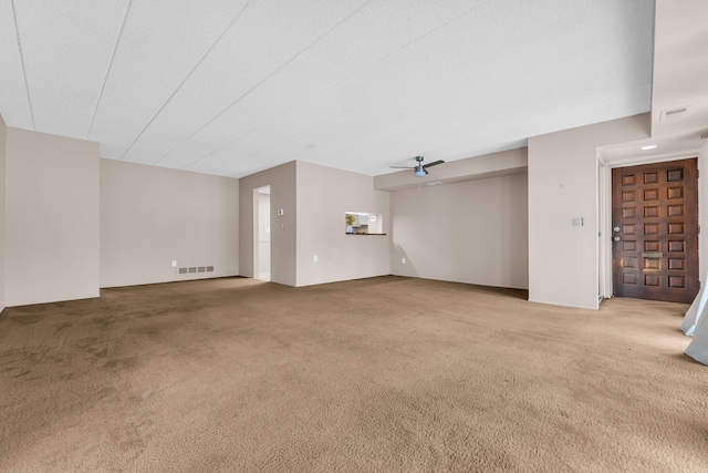 unfurnished living room with ceiling fan and carpet