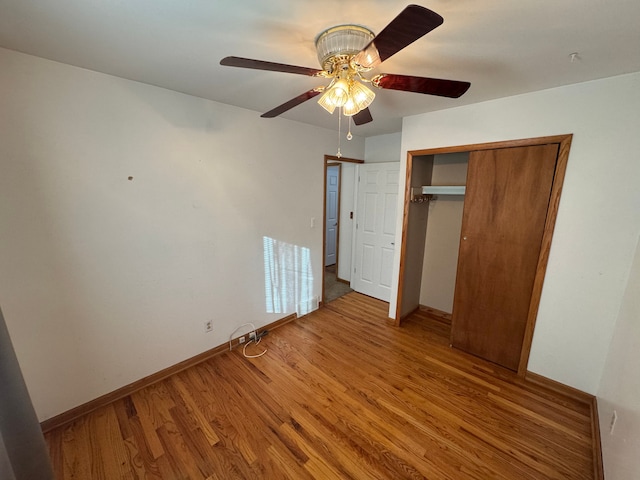 unfurnished bedroom with ceiling fan, wood-type flooring, and a closet