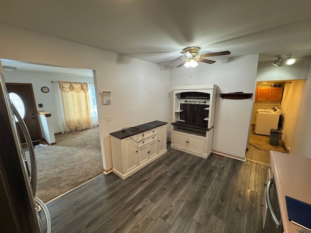 kitchen featuring washer / dryer, ceiling fan, dark hardwood / wood-style floors, and stainless steel refrigerator