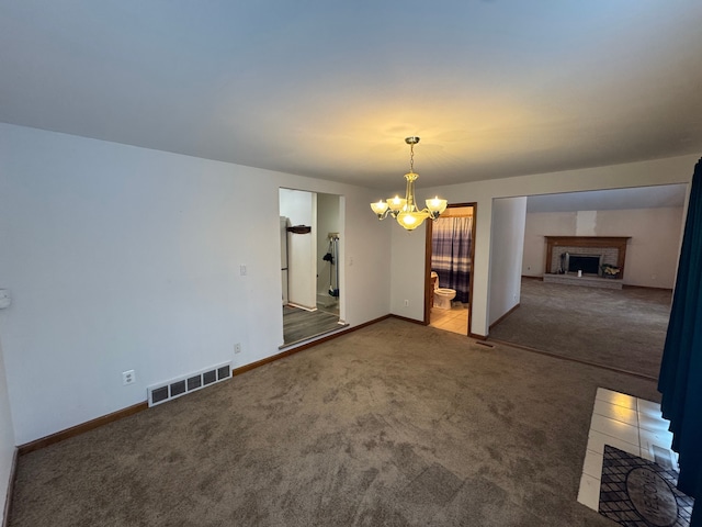 unfurnished room featuring a notable chandelier and carpet flooring