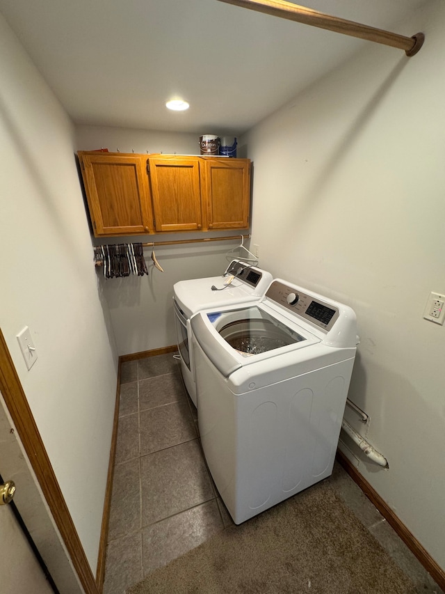 laundry room featuring washer and dryer and cabinets