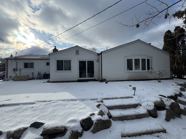 snow covered property with central AC