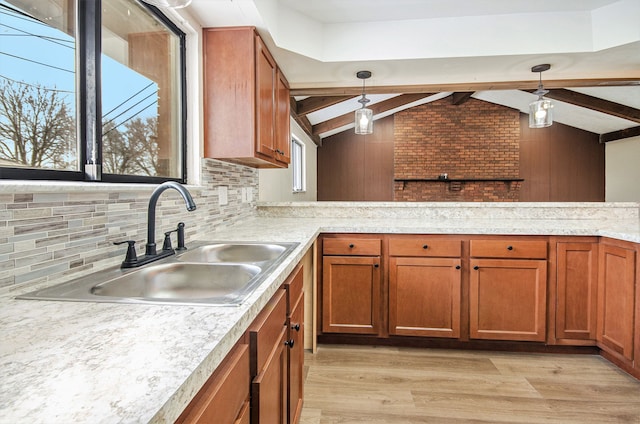 kitchen featuring light hardwood / wood-style floors, backsplash, vaulted ceiling with beams, hanging light fixtures, and sink