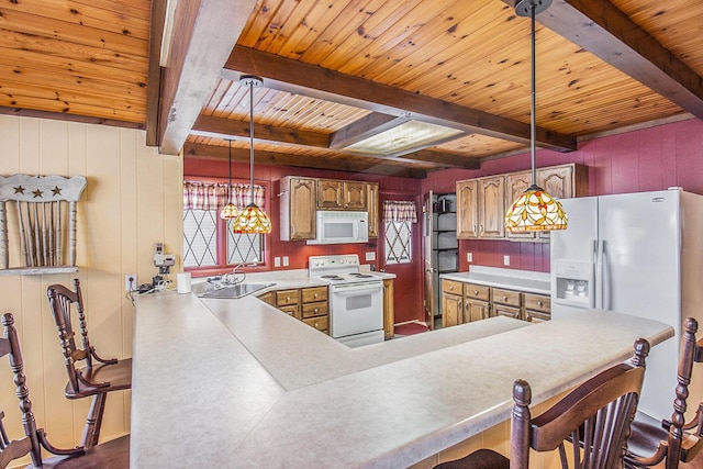 kitchen with wooden walls, white appliances, hanging light fixtures, beam ceiling, and sink