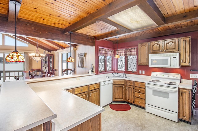 kitchen featuring beamed ceiling, pendant lighting, and white appliances