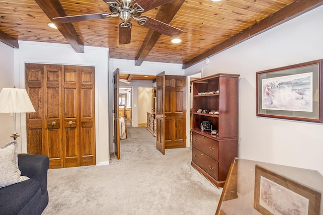 living area with light carpet, ceiling fan, wood ceiling, and beamed ceiling