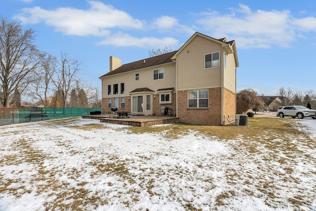 snow covered property featuring central AC