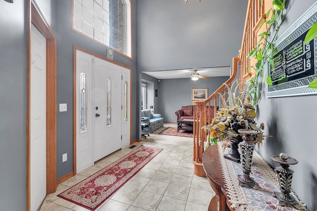 foyer with ceiling fan and a towering ceiling