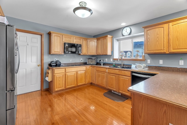 kitchen with sink, light hardwood / wood-style floors, and black appliances