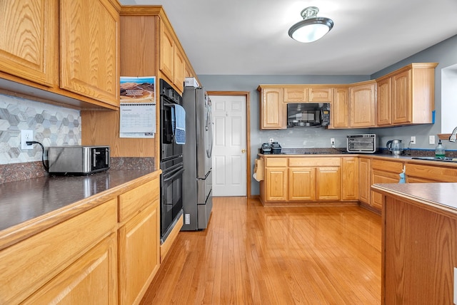 kitchen with decorative backsplash, light hardwood / wood-style floors, and black appliances