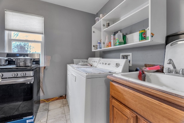 laundry room with light tile patterned floors, sink, and washing machine and clothes dryer