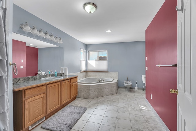 bathroom featuring tiled tub, vanity, and a bidet