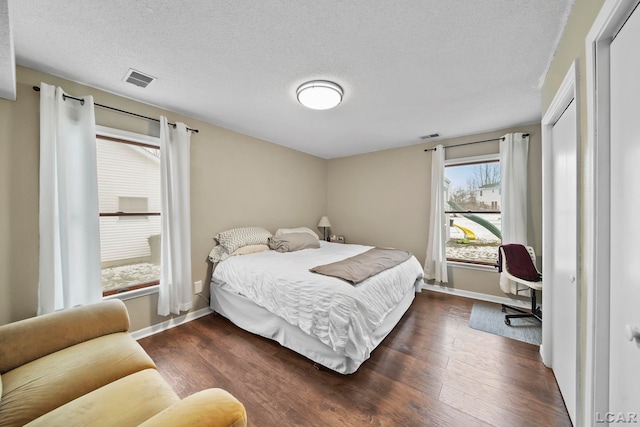 bedroom featuring dark wood-type flooring and a textured ceiling