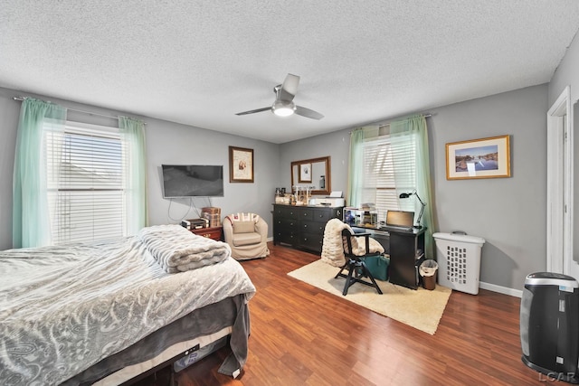 bedroom featuring ceiling fan, a textured ceiling, and dark hardwood / wood-style floors