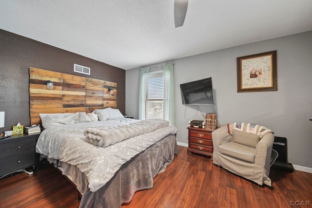 bedroom featuring a textured ceiling, ceiling fan, and dark hardwood / wood-style flooring