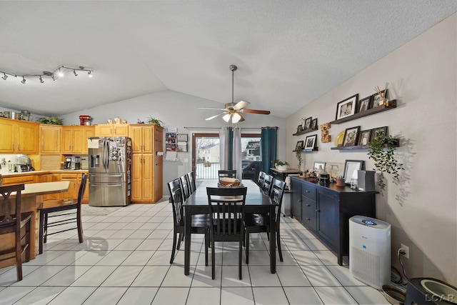 dining room with light tile patterned floors, a textured ceiling, vaulted ceiling, and ceiling fan